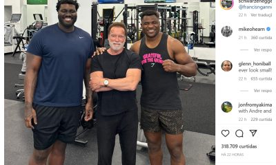 Arnold Schwarzenegger cercado por Francis Ngannou e Mekhi Becton em Los Angeles.