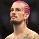 Sean O'Malley com o cabelo rosa e trançado durante uma de suas lutas no UFC