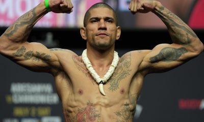 Alex Poatan flexiona os músculos ao subir na balança da pesagem cerimonial do UFC 276.