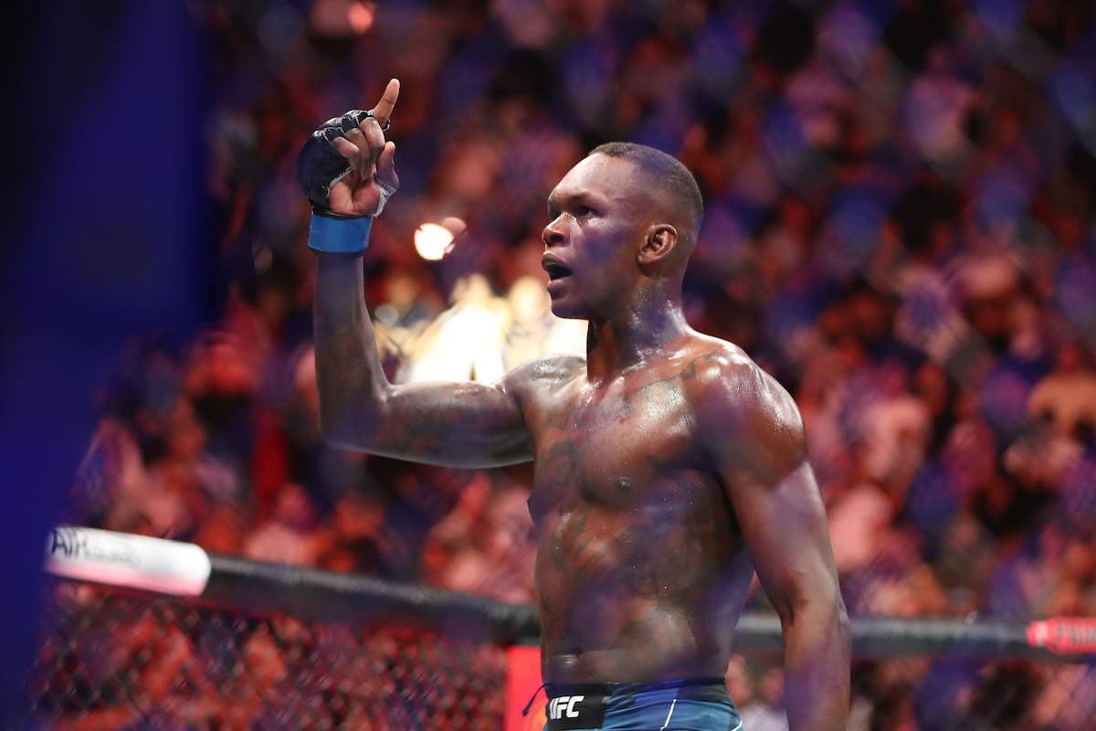Com o dedo indicador para o alto, Adesanya comemora sua vitória sobre Poatan no UFC 287