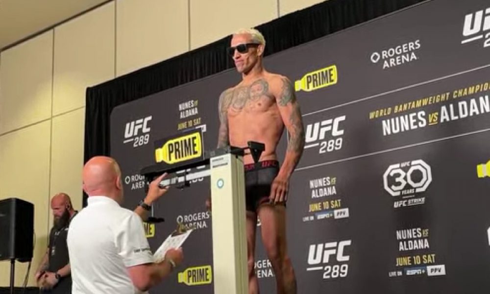 Charles Do Bronx sobre na balança de óculos escuros em pesagem do UFC