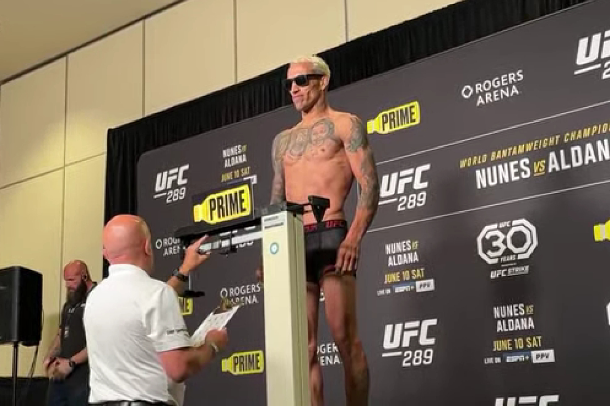 Charles Do Bronx sobre na balança de óculos escuros em pesagem do UFC