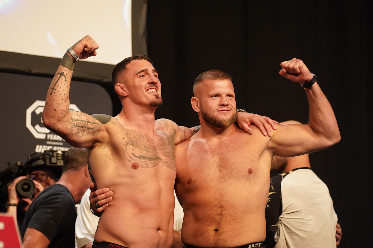 Tom Aspinall e Marcin Tybura se abraçam na pesagem cerimonial do UFC Londres.