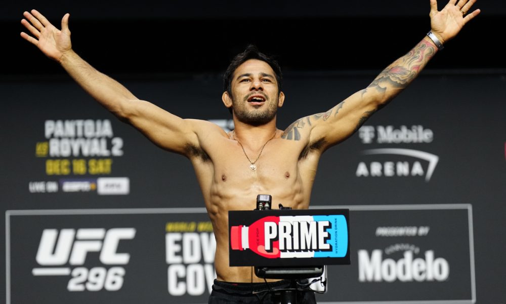 Alexandre Pantoja posa na balança da pesagem cerimonial do UFC 296.