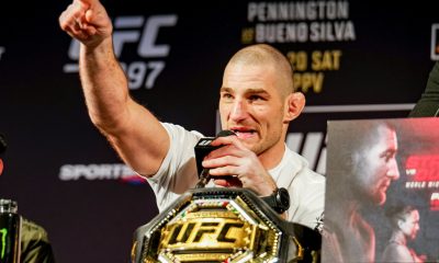 Sean Strickland com o dedo em riste ao lado do cinturão na coletiva do UFC 297