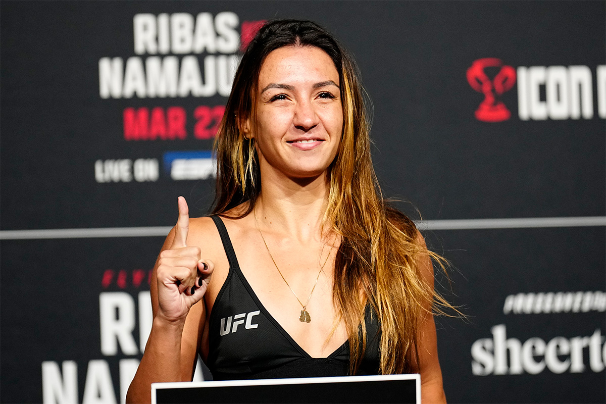 Amanda Ribas posa para fotos em cima da balança do UFC logo após bater o peso da divisão dos moscas
