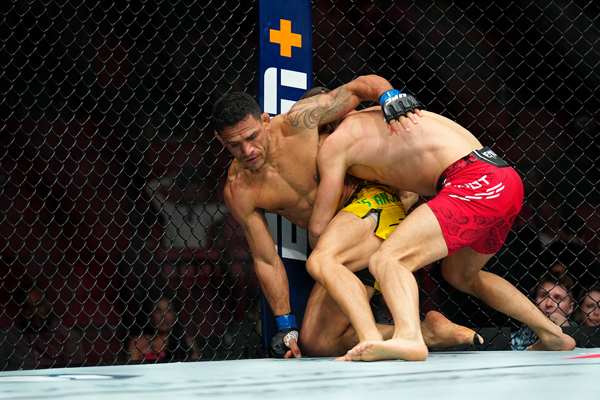 Rafael dos Anjos tenta se levantar após ser derrubado por Mateusz Gamrot