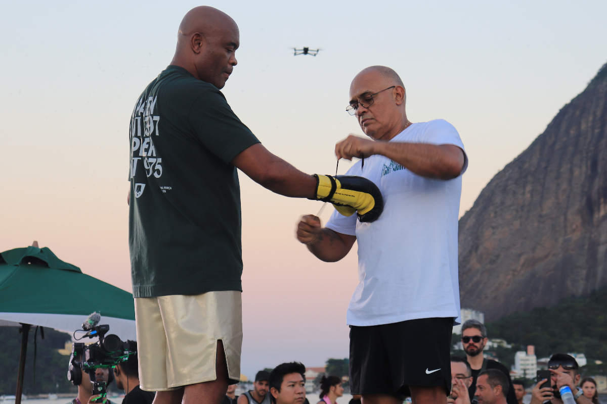 Anderson Silva observa o treinador Luiz Carlos Dorea ajustar suas luvas antes do treino aberto para sua luta de boxe contra Chael Sonnen
