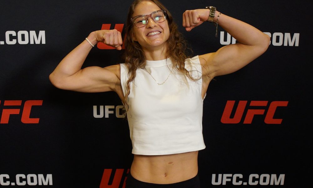 Sorridente, Rondinha flexiona os braços para mostrar o trabalho de ganho de massa