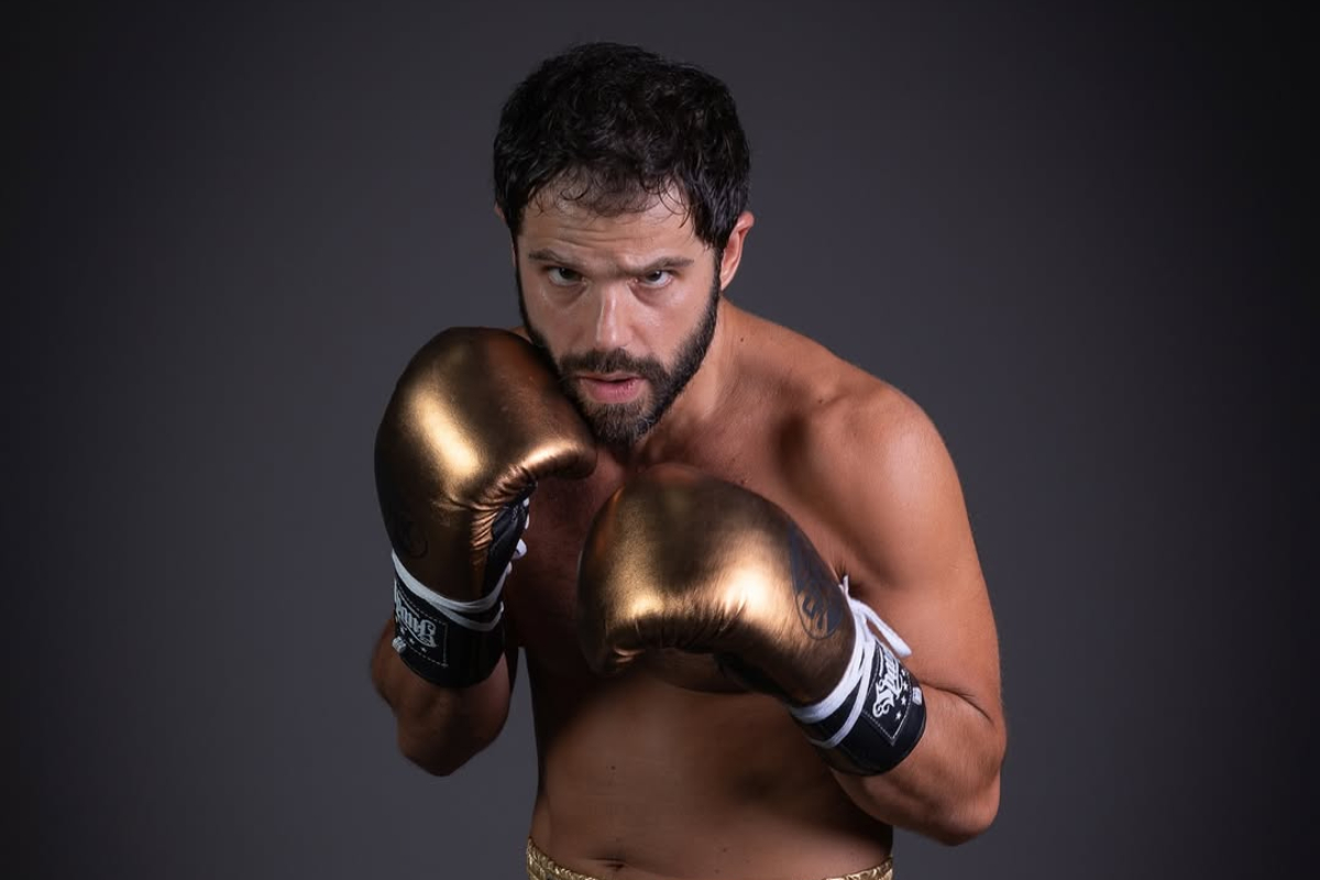 Duda Nagle com os punhos cerrados de luva dourada de boxe
