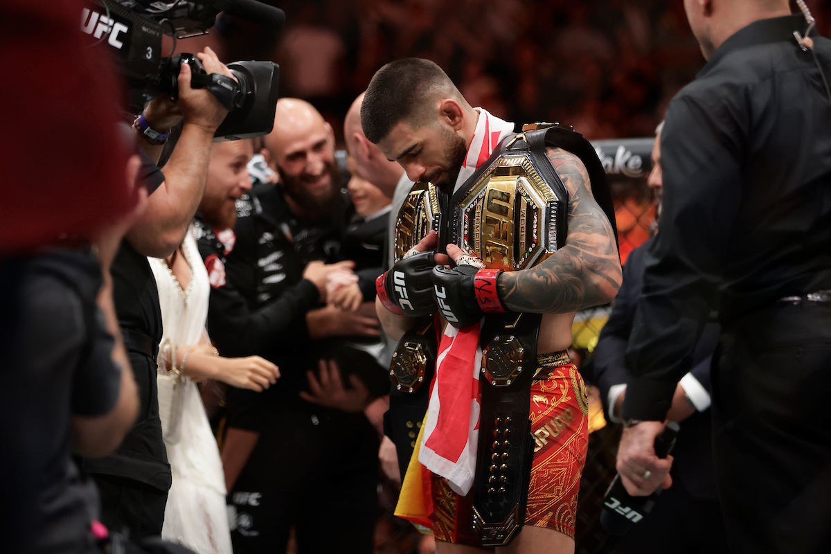 Ilia Topuria comemorando após vitória que garantiu o cinturão peso-leve no UFC 317