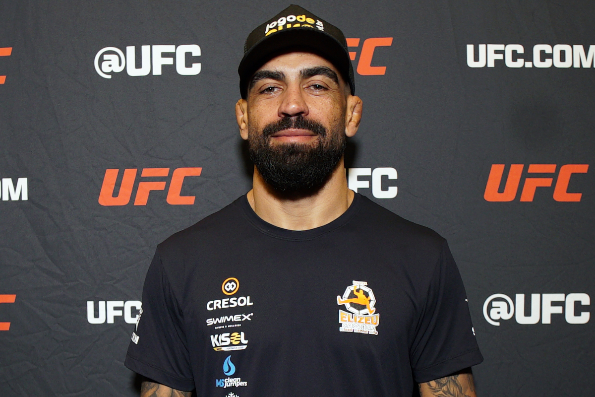 De boné, Elizeu Capoeira posa para foto no media day do UFC Vegas 108