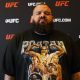 Com camisa estilizada de Poatan, Plinio Cruz posa para foto no media day do UFC 320