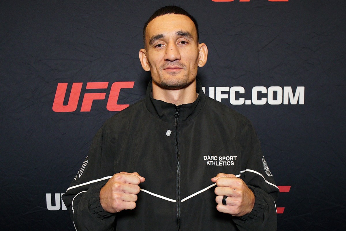 De punhos cerrados, Max Holloway posa para foto no media day do UFC 326