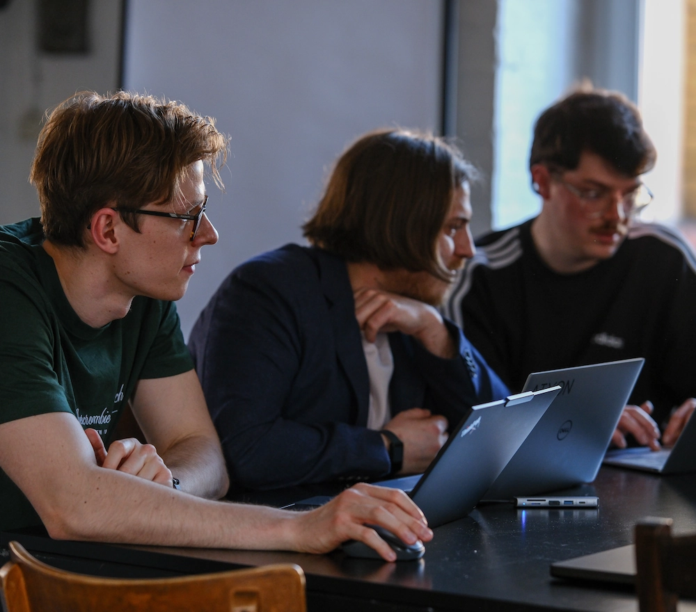 Produktives-Teamwork Volle Aufnahme von konzentrierten Kollegen, die am Schreibtisch mit Mobiltelefon und Laptops arbeiten.