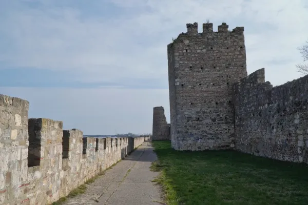 Die steinernen Mauern und Türme der Smederevo Festung in Serbien, mit einem Gehweg, der sich entlang der Mauer schlängelt.