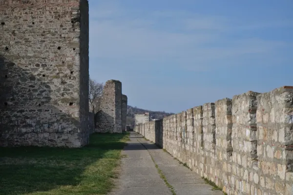 Un chemin serpente à travers les murs de la forteresse de Smederevo, Serbie, avec des tours en pierre et une ville en arrière-plan.