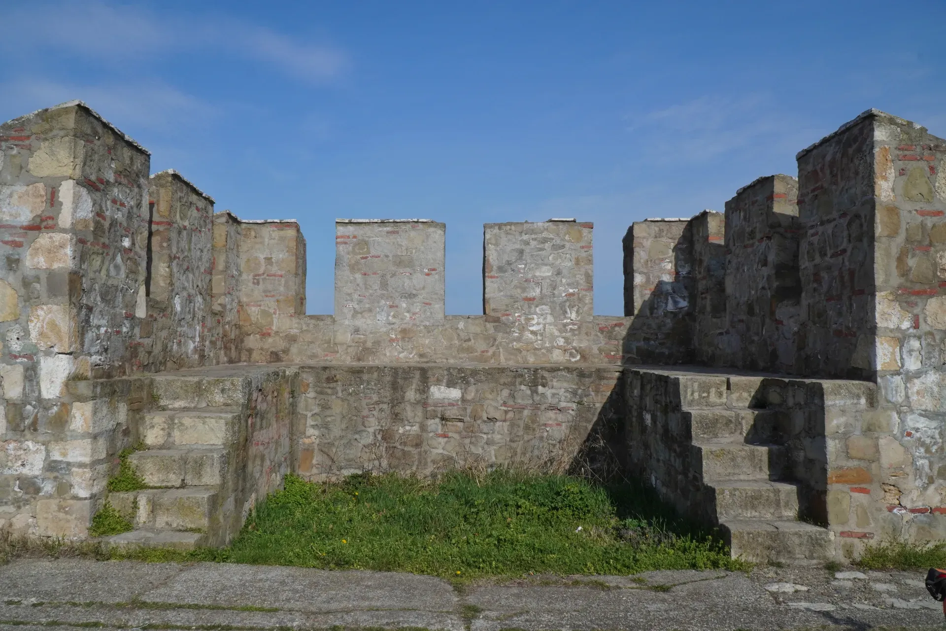 Steinerne Zinnen und Treppen der Smederevo Festung mit blauem Himmel im Hintergrund.