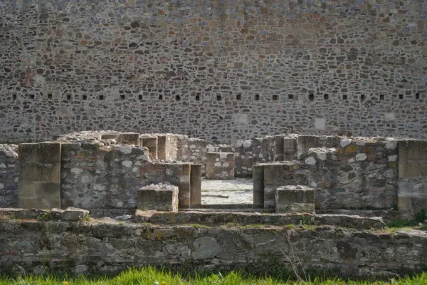 Las ruinas de la Fortaleza de Smederevo, con una gran muralla de piedra al fondo y muros de piedra derrumbados en primer plano.