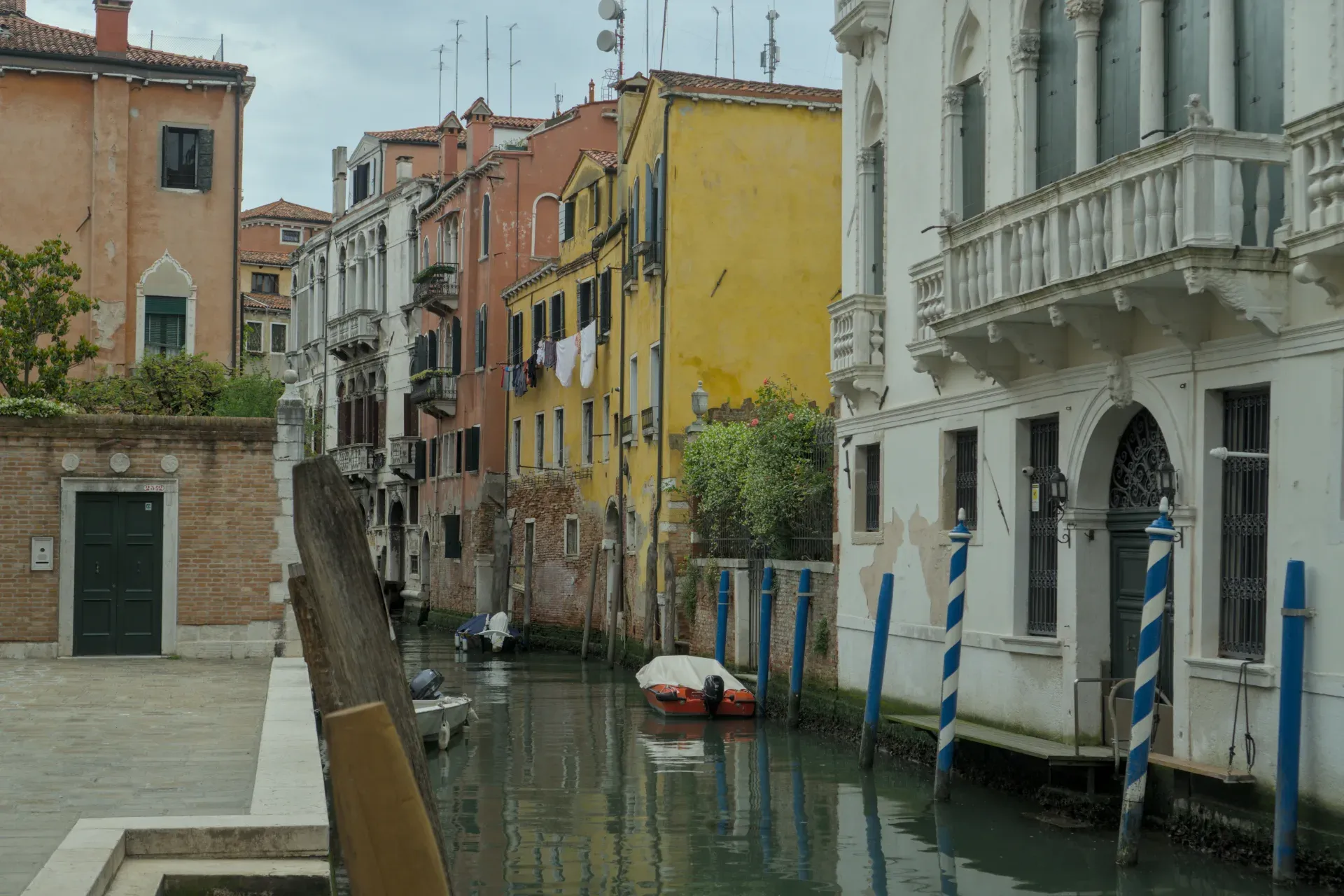 Un sereno canal veneciano con casas coloridas tradicionales y superficies de agua reflectantes.