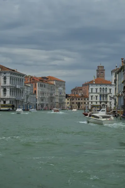 Canal Grande a Venezia con edifici storici e barche sotto un cielo drammatico.