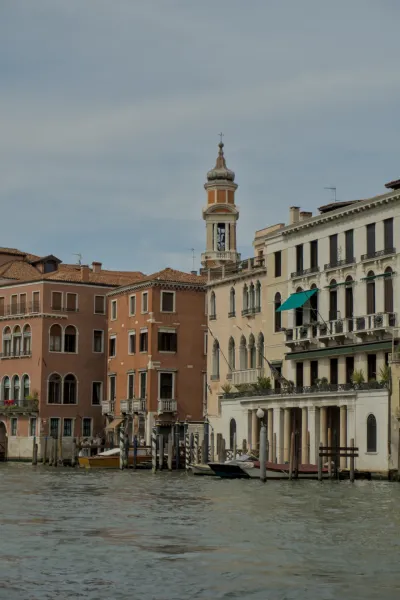 Photographie de bâtiments sur le Grand Canal à Venise, Italie, avec un clocher proéminent et des bateaux dans l'eau.
