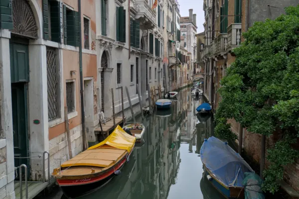 Un canal étroit à Venise, bordé de bâtiments historiques et de bateaux endormis, une œuvre d'art idéale pour les intérieurs.