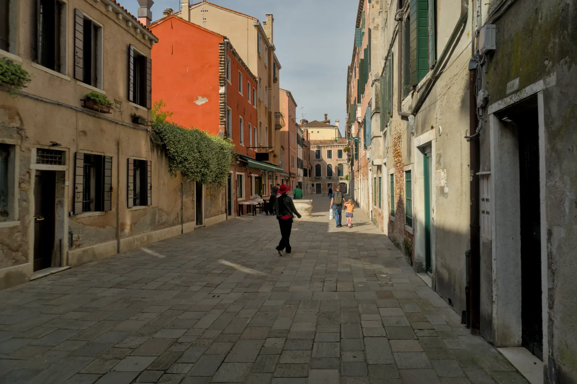 Fotografía de bellas artes de un callejón estrecho en Venecia con edificios de colores pastel y suelo empedrado.