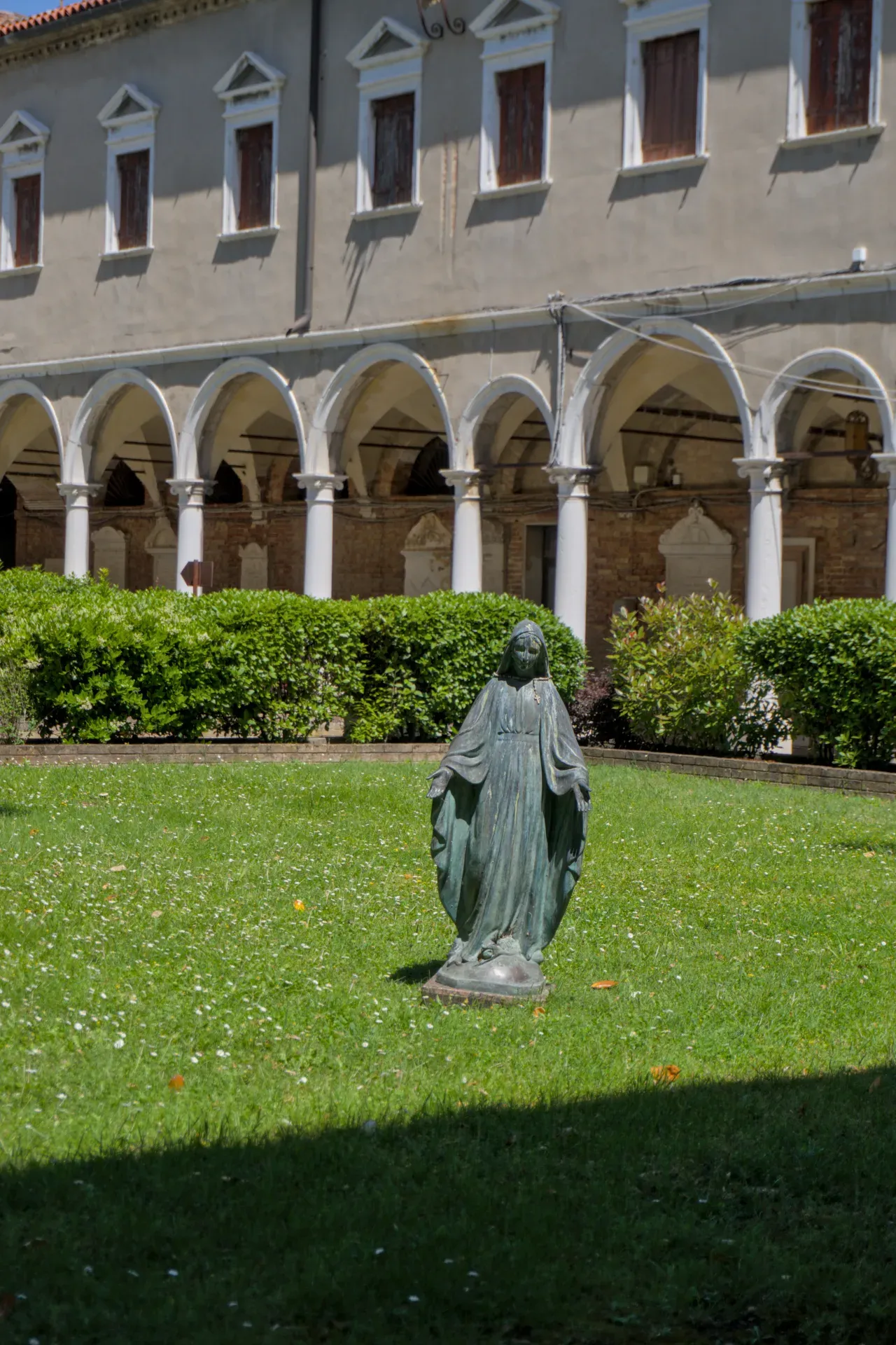 Statua in bronzo della Madonna nel cortile del Cimitero San Michele a Venezia.