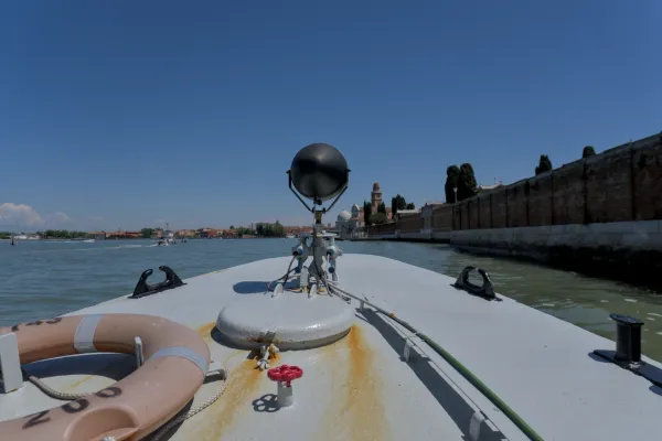 Blick auf das Wasser von einem Boot aus, auf dem Weg von San Michele nach Murano, mit der Skyline von Venedig am Horizont.