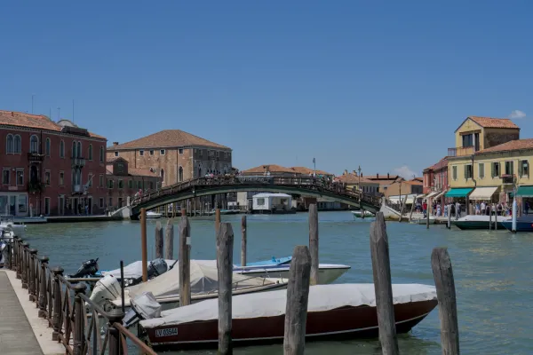 Kanalbrücke auf Murano, Italien, mit Booten im Wasser.
