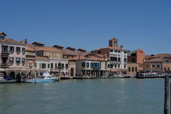 L'architecture distinctive de l'île de Murano à Venise avec des bateaux sur le canal sous un ciel bleu clair.