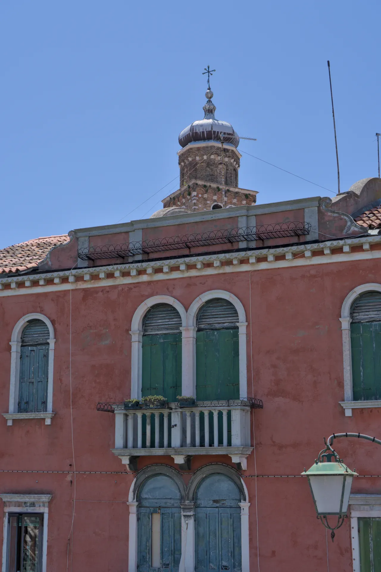 Ventanas y cúpula en Murano, una isla en Venecia, Italia, con arquitectura típica y persianas verdes.