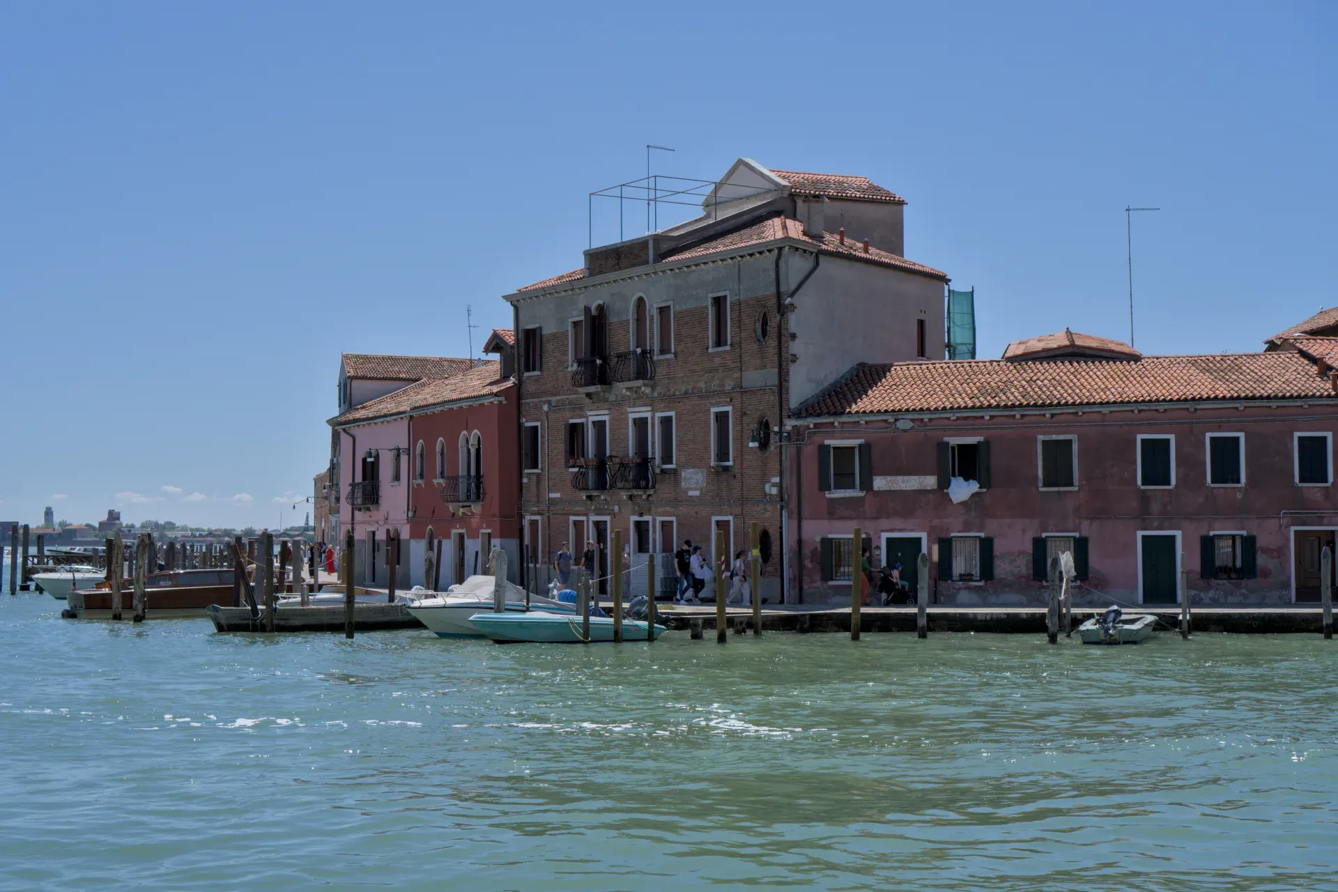 Casas y barcos coloridos en el muelle de la isla de Murano, Venecia, a la luz del día.