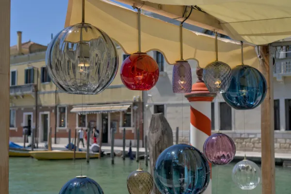 Lampadari in vetro di Murano appesi in vari colori sopra un canale d'acqua a Venezia, Italia.