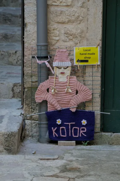 Handgestricktes Schild mit der Aufschrift 'Kotor' und 'Local hand made shop' in Montenegro.
