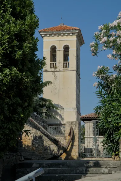 Un vecchio campanile si erge su una scala di pietra con una grande ancora arrugginita a Herceg Novi, Montenegro.
