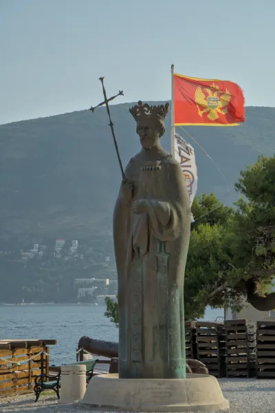 Ritratto di un monumento di re a Herceg Novi, Montenegro, con lo stemma di stato e il mare sullo sfondo.