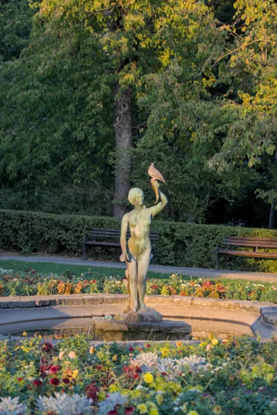 Skulptur eines Mädchens mit einem Füllhorn, auf dem ein Vogel sitzt, in einem Park in Novi Sad, Serbien.