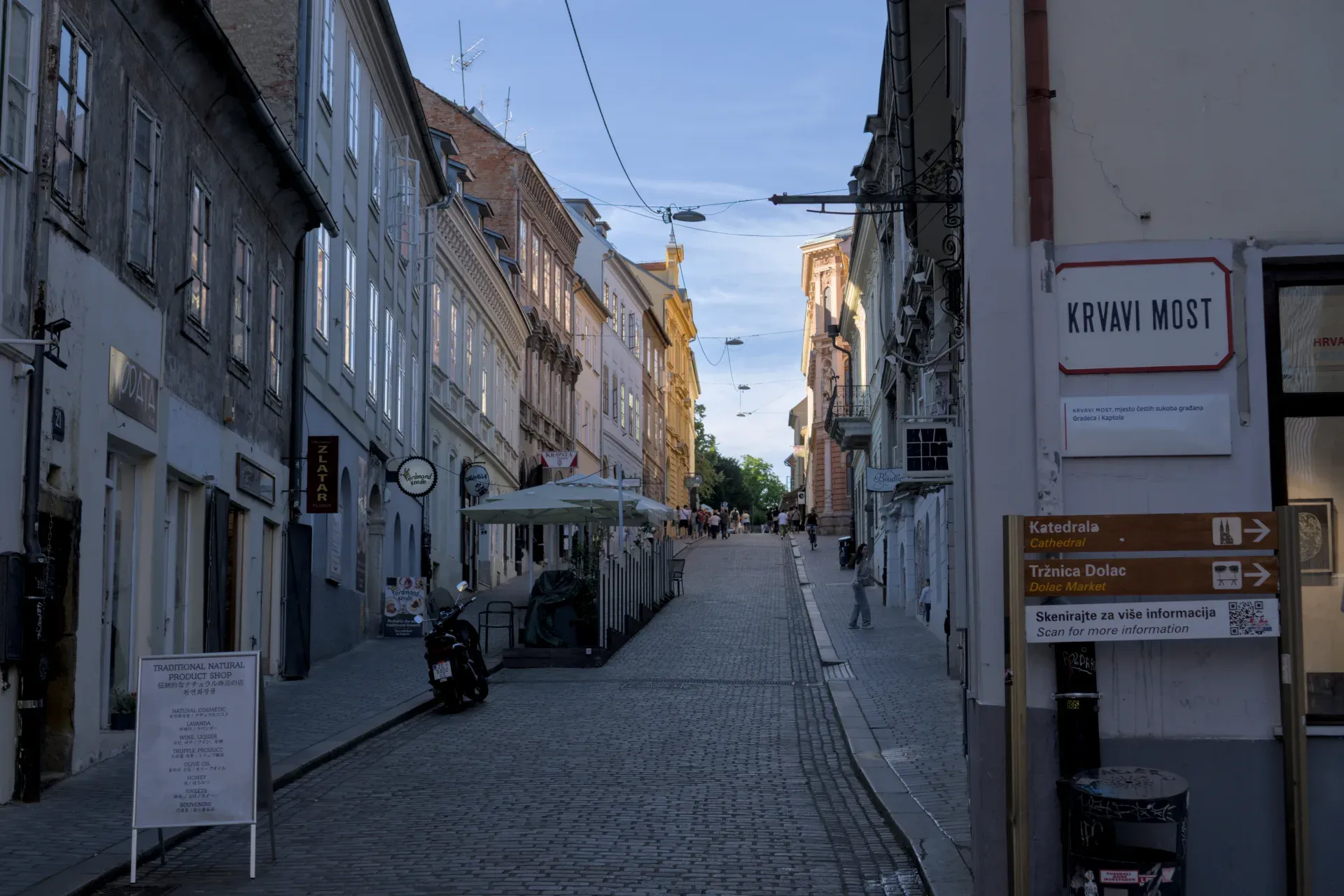 Eine Kopfsteinpflastergasse in Zagreb mit historischen Gebäuden und abendlicher Beleuchtung.
