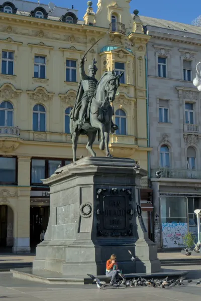 Das Reiterdenkmal von Ban Jelačić in Zagreb, Kroatien, mit einem Menschen, der Tauben füttert.