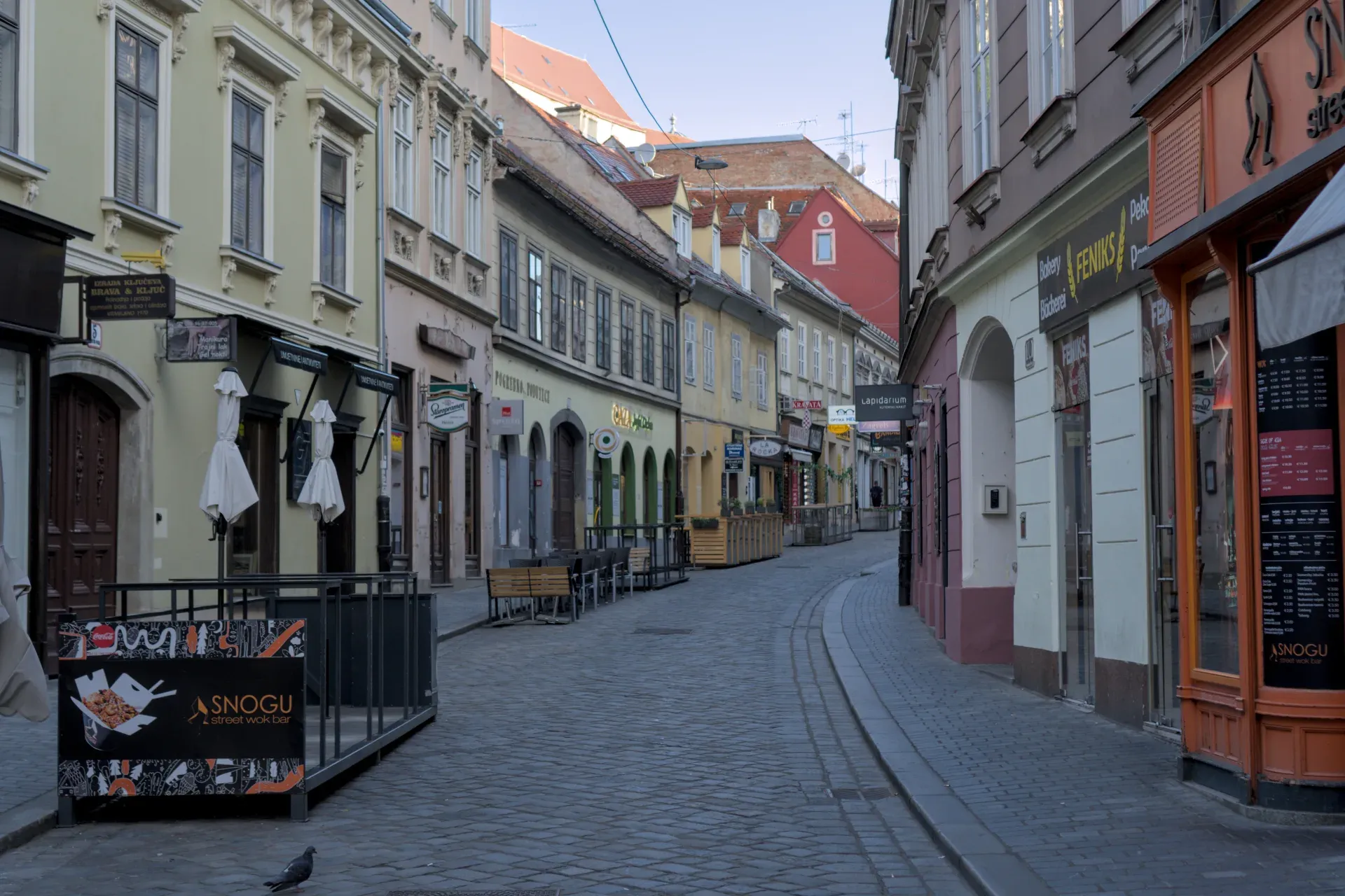 Une ruelle étroite et pavée à Zagreb avec des bâtiments historiques et des boutiques, capturée en format paysage.