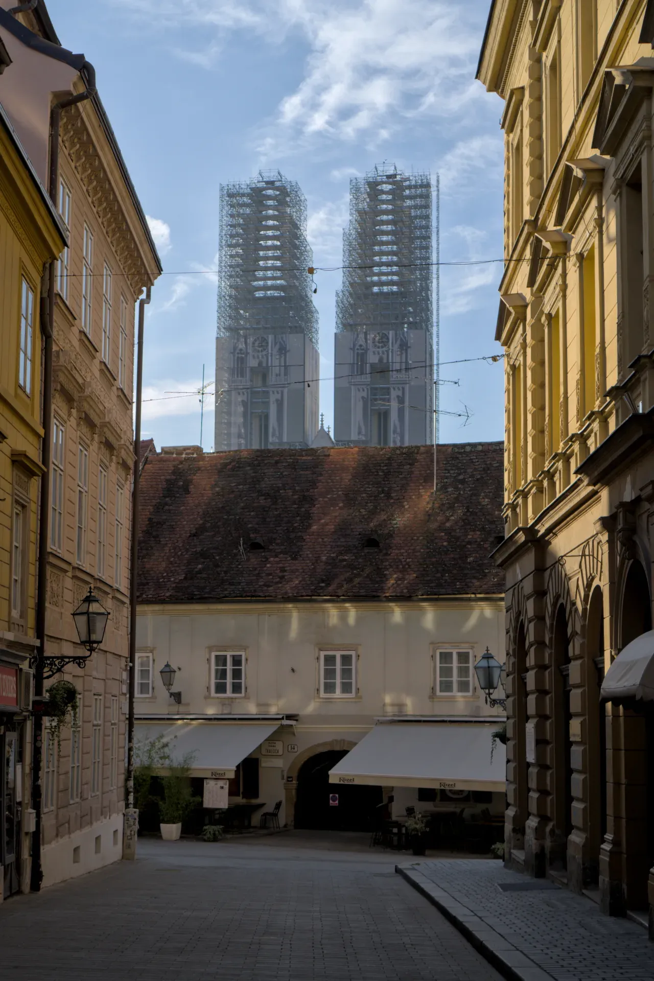 Zagreb katedrala u skelama, pogled iz uske ulice, okružena povijesnim zgradama.