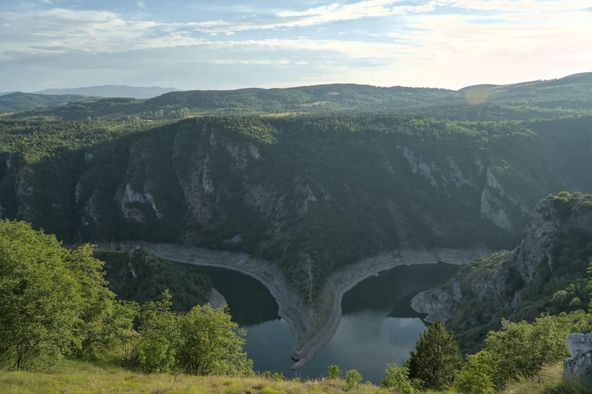 Kanjon Uvac u Srbiji sa svojim karakterističnim rečnim tokom u suton, okružen pošumljenim brdima.