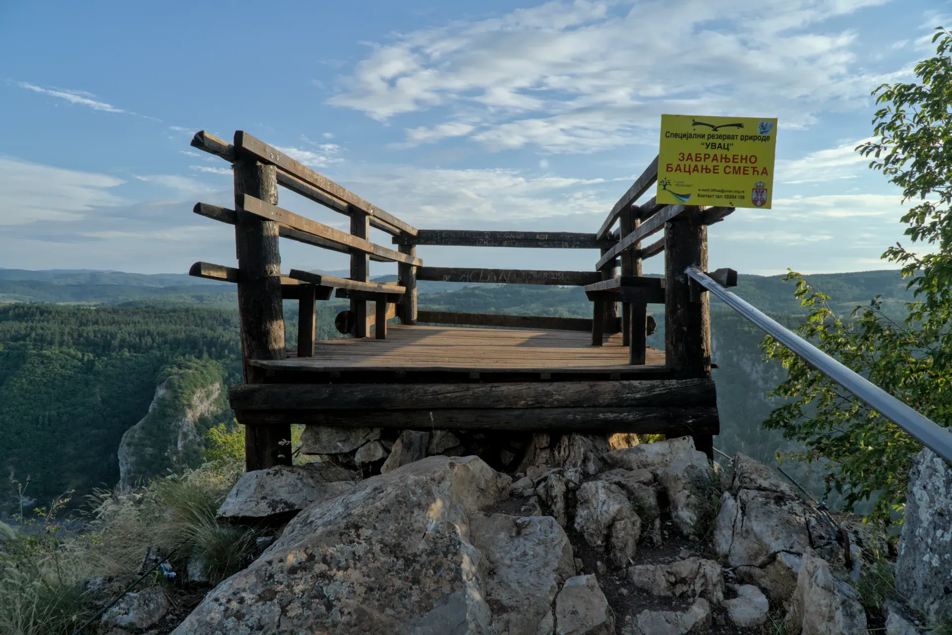 The wooden "Prayer" viewpoint overlooks the lush Uvac Canyon in Serbia during daylight.