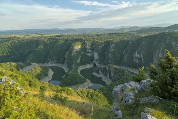Panoramablick auf die kurvenreiche Uvac-Schlucht in Serbien, umgeben von üppig grünen Wäldern und Felsformationen.