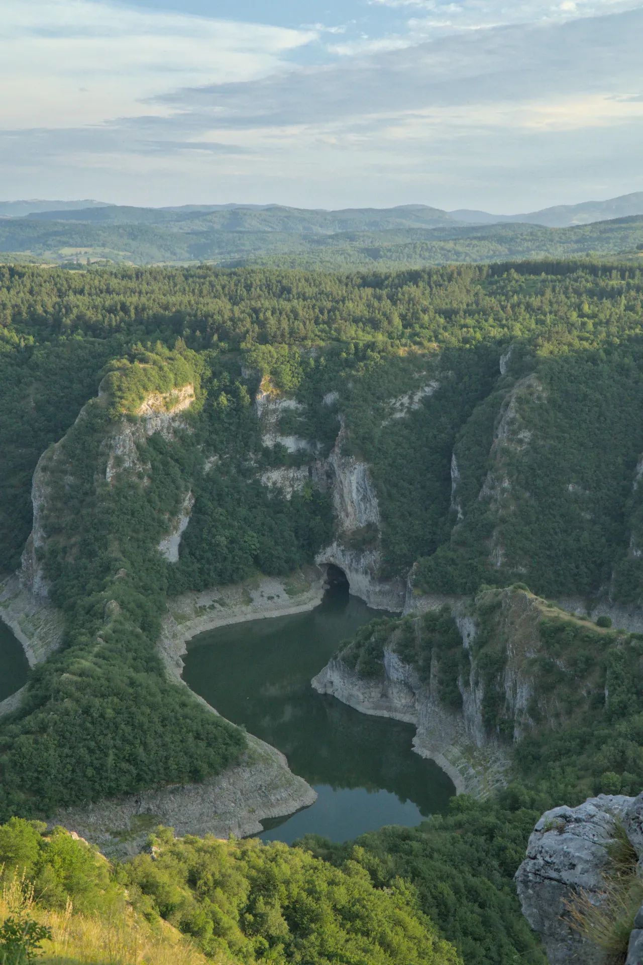 Panorama der Uvac-Schlucht in Serbien mit tiefem grünen Tal, Fluss und bewaldeten Hängen.
