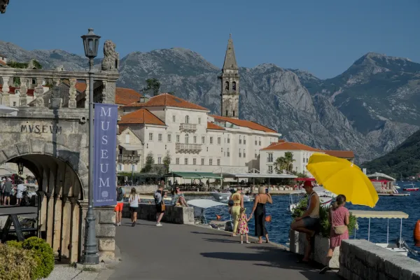 Perast Promenade mit historischen Gebäuden und Bergen im Hintergrund.