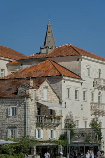 Šetalište Perasta pri zalasku sunca sa karakterističnim krovovima i zgradama.