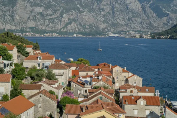 Vista panorámica desde el campanario de Perast sobre la Bahía de Kotor con casas y montañas.